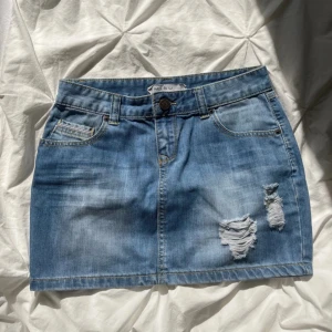 Jeanskjol - Jeanskjol med slitningar. Inga tecken på användning. MIDJEMÅTT: 36.5 cm, LÄNGD: 34 cm