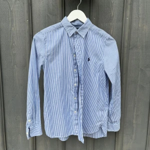 Polo Ralph Lauren skjorta - Blårandig Polo Ralph Lauren skjorta, perfekt för sommarn. Strl: 16 i barn men sitter som xs. Fråga vid funderingar. Pris kan diskuteras.