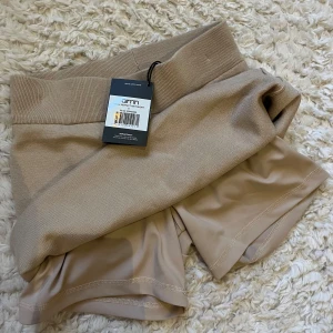 Beige kjol med inbyggda shorts aim’n  - Jag säljer en super bekväm beige kjol med inbyggda shorts! Man kan välja själv om man vill vika ner den eller ej och bestämma hur den ska sitta. Aldrig använd så prislappen är fortfarande kvar!
