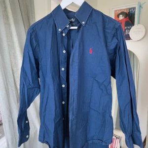Raplh lauren skjorta - Säljer en marinblå raplh lauren skjorta för ett bra pris! Skjortan är enkel att kombina med många plagg! 