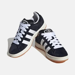 Adidas Campus sneakers svart/vit mocka - Adidas Campus sneakers i svart mocka med klassiska vita ränder och vit sula. Skorna har rund tå, platt gummisula och snörning med breda vita skosnören. Perfekt för dig som gillar retrostil och streetwear. dem är smått använda men är i väldigt bra skick 
