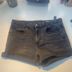 Svarta jeansshorts från Zara - Snygga svarta jeansshorts från Zara med klassisk femficksmodell och uppvikta benslut. Shortsen har normal passform och är tillverkade i mjukt denimtyg. Perfekta för en chill sommarlook.