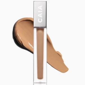 CAIA flytande concealer beige - Flytande concealer från CAIA i en snygg beige nyans i färgen 4n. Kommer i en stilren, genomskinlig tub med silverlock och applikator. Perfekt för att täcka mörka ringar och ojämnheter. Ger ett naturligt resultat och smälter in fint i huden. Helt ny och aldrig andvänd