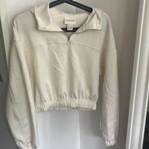 Vit hoodie med half zip från H&M Move - Snygg vit hoodie från H&M Move i storlek XS. Tröjan har en halv dragkedja framtill, huva och resår i midjan för en schysst passform. Den här tröjan känns så skön mot huden. Jag tror aldrig att tröjan kommit till någon användning för mig men den är superfin!❤️