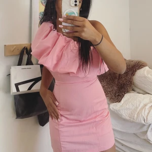 Rosa one shoulder klänning - Säljer en söt rosa klänning med one shoulder-design och stor volangdetalj över axeln.  Slutsåld 💕TRYCK INTE KÖP INTE utan att skriva först 
