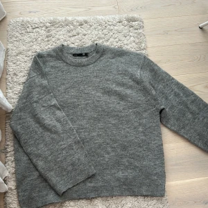 Grå stickad tröja från lager 157 - Mysig grå stickad tröja från lager 157 med rund halsringning och långa ärmar. Perfekt för kyliga dagar och enkel att matcha med olika outfits. Bra skick. Stor i storleken 