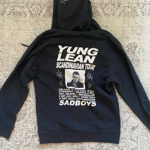 Svart hoodie Yung Lean Scandinavian Tour - Svart hoodie med dragkedja från Yung Lean & Sad Boys Scandinavian Tour. Tryck med turnédatum och porträtt på ryggen, samt stjärnmotiv fram och på huvan. I princip oanvänd och utan defekter.