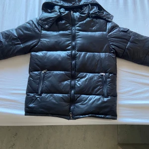 Moncler Maya - En äkta Moncler Maya jacka, kvitto finns. Sälj eftersom den inte längre är i behov då min bror köpt en ny. Storlek 2 (S/M). Använd ett par gånger under vintern, sen dess har den hängt kvar på hyllan. Vid snabb affär kan pris diskuteras. Köpare står för frakt. 