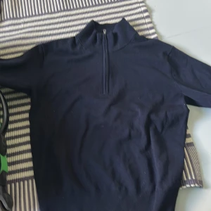 Mörkblå tröja med halv dragkedja - Säljer en mörkblå tröja med hög krage och halv dragkedja framtill. Tröjan har lång ärm och en stilren, enkel design som passar perfekt till vardags. Materialet känns mjukt och bekvämt. Väldigt snygg men passade ej mig. Storlek xs