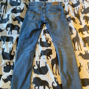 Ljusblå jeansbyxor från nudie - Säljer ett par klassiska ljusblå jeans från nudie. Modellen är lean Dean och dom är i princip nyskick. Nypris ligger på 1600 skriv vid frågor