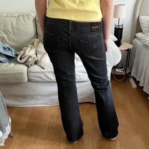 Svarta bootcut jeans från Herrlicher - Säljer ett par svarta bootcut jeans från Herrlicher med dekorativa fickor fram och bak. Jeansen har låg midja. 
