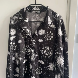 Svarta vida byxor med astrologiskt mönster pyjamas det från Monki - Säljer ett par svarta byxor från Monki med vitt astrologiskt print med solar, månar och stjärnor. Byxorna har dragsko i midjan och är vida i modellen. Perfekta för dig som gillar unika och coola mönster!