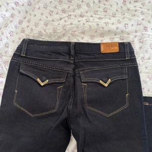 Mörkblå bootcutjeans - Snygga mörkblå bootcut med gulddetaljer på fickorna!💕💕