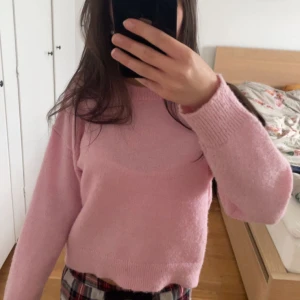 Ljusrosa stickad tröja - Mysig ljusrosa stickad tröja med rund hals och långa ärmar. Perfekt för lager-på-lager och passar till både jeans och kjol. Tröjan har en enkel och klassisk design.