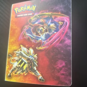 Pokémonkort i samlarpärm - Säljer en samlarpärm för Pokémonkort med färgglatt omslag som visar Solgaleo och Lunala. Inuti finns bland annat ett Dragonite-kort med regnbågsbakgrund, ett glittrande Mega Charizard EX-kort och ett Machamp-kort. Perfekt för Pokémon-samlare! Kom privat för mer bilder på allt som finns i pärmen pris kan diskutera 