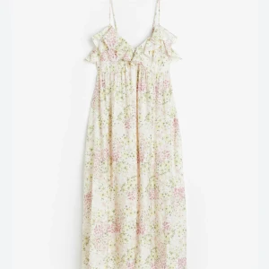 Blommig långklänning med volang - Söt långklänning med blommigt mönster i ljusa färger. Klänningen har smala axelband, volangdetalj vid urringningen och en luftig passform. Perfekt för varma dagar och somriga tillfällen. 💕💕