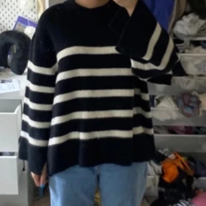 Svart och vit randig stickad tröja - Säljer en oversized stickad tröja med breda svarta och vita ränder. Tröjan har lång ärm och en lös passform, perfekt för en avslappnad stil. Mjuk och skön att bära.