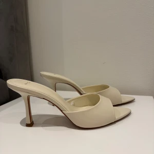 Beige klackade sandaler från Mango (MNG) - Säljer ett par stilrena beige sandaler med klack från Mango (MNG). Skorna har öppen tå, bred rem över foten och en elegant spetsig tå. Perfekta för dig som gillar minimalistisk och trendig design. Helt nya (aldrig använda)!! Storlek 40 :) Även helt slutsålda överallt!! 🥰(originalpris 430kr)