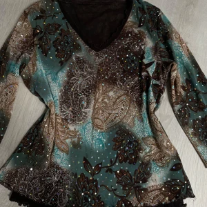 Glittrig långärmad topp med paisleymönster - Säljer en så sjukt söt och unik långärmad topp med v-ringning, trekvartsärmar och glittriga detaljer. Toppen har ett paisley- och bladmönster i turkos, brunt och svart. 