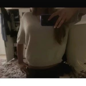 kräm vit stickad tröja med kort ärm - Mysig kräm vit stickad tröja med korta ärmar och avslappnad passform. Perfekt för lager-på-lager och enkel att matcha med olika outfits.