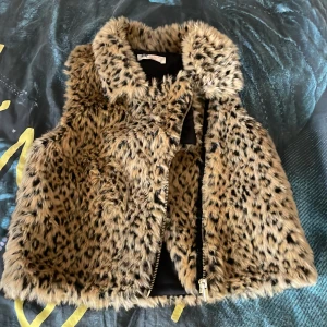 Leopardmönstrad pälsväst - Säljer en fluffig och mjuk pälsväst från H&M i leopardmönster i storlek 146. Säljs pågrund va för liten, den var för kort för mig o lite för tajt