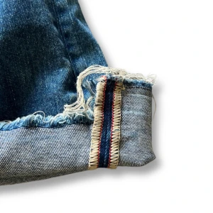 Flared Vintage Selvedge Jeans Från Replay - Säljer ett par blå selvedge jeans med raka ben och rå, fransig kant nertill. Klassisk femficksmodell med tydlig selvedge-detalj på insidan av benslutet. Perfekta för dig som gillar en autentisk denimlook. Står strlk 27 men sitter som W29 L30