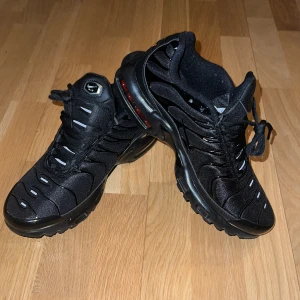 Svarta Nike Air Max Plus TN sneakers - Säljer ett par *HELT NYA* svarta Nike Air Max Plus TN sneakers med klassisk vågig design och synlig Air Max-dämpning i sulan. Skorna har snörning, mesh- och syntetpaneler samt diskreta TN-loggor på hälen. Perfekta för dig som gillar streetwear.👍🙌 Jag säljer dessa sneakers eftersom jag fick de i present och de var lite för små för mig…                                                        *Pris kan diskuteras lagom* Hör gärna av dig vid frågor😁