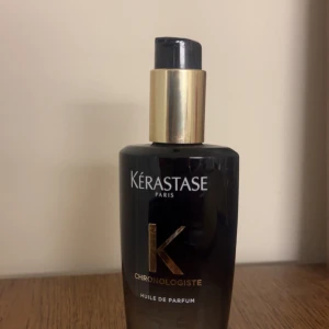 Kérastase Chronologiste Huile de Parfum - Pennan visar hur mycket som används , väldigt dryg parfym hår olja ! Lyxig parfymolja från Kérastase i en elegant svart flaska med gulddetaljer. Flaskan har en pump och rymmer doftoljan Chronologiste, som ger håret en exklusiv doft och glans. Perfekt för dig som vill ha en sofistikerad hårparfym.