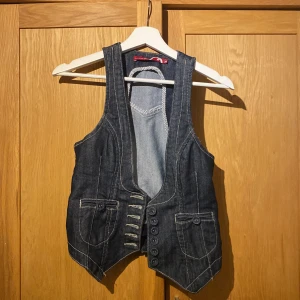 Mörk jeansväst med knappar - Snygg mörkblå jeansväst i stl 34