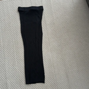 Svart ribbad långkjol S Zara super strech  - Säljer en svart långkjol med ribbad struktur. Kjolen har en rak och smal passform som sitter snyggt och är enkel att matcha med olika toppar. Perfekt för dig som gillar stilrena och minimalistiska plagg. Super strech