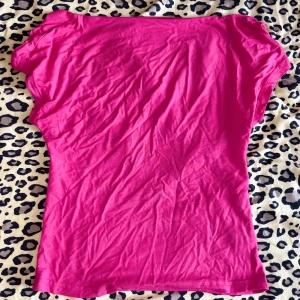 Rosa topp med öppen rygg - Säljer en snygg rosa topp i stretchigt bomullsmaterial. Toppen har korta ärmar och en djup öppen rygg! (Ursäktar den skrynkliga bilden haha)💕