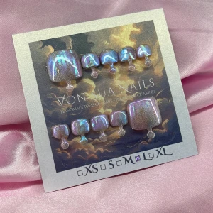 Lilux (L);Square Toe  - Handgjorda toe press-on naglar i storlek L: 17 mm, 10 mm, 10,5 mm, 10 mm, 8 mm . Naglarna har en fyrkantig form och skimrar i lila, blått och rosa med holografisk effekt. Perfekt för dig som vill ha unika och glittriga naglar utan att gå till salong.