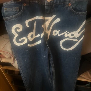 Ed hardy insperade mörkblå jeans - Snygga blå jeans från MONKI inspererade av Ed Hardy loggan. Har aldrig använt jeansen så dom är i nyskick. Väldigt bra material på jeansen. Jag har målat Ed hardy loggan själv. Mått: Midja: 37 Innerbenslängden: 78 Kom gärna med prisförslag 