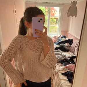 Beige stickad kofta med vid ärm - Säljer en beige stickad kofta med snyggt virkat mönster och vida ärmar. Perfekt att slänga över ett linne för en chill och trendig look. Koftan har en lös passform och är supermjuk och luftig.