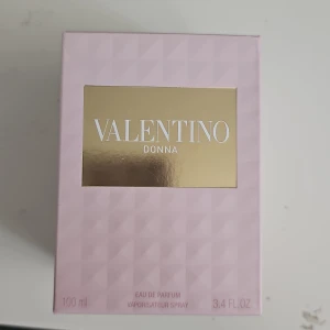 Valentino Donna Eau de Parfum 100ml - Lyxig parfym från Valentino, Donna Eau de Parfum, 100 ml. Flaskan är i rosa, fasetterat glas med gulddetaljer och nitar vid halsen. Förpackningen är ljusrosa med guldlogga. En elegant och feminin doft i exklusiv design.