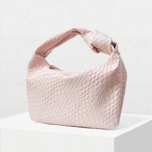 Ljusrosa väska  - Superfin ljusrosa axelväska med unik flätad struktur och knut på handtaget. Väskan har en mjuk, boxig form och känns både trendig och stilren. Perfekt för dig som vill ha en snygg accessoar som sticker ut lite extra.