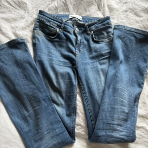 Blå  jeans från Zara - Snygga blå jeans från Zara som sitter lite tajtare uppåt på bena som sedan går ut med längden. Jeansen är lågmidjade 🩵🩵