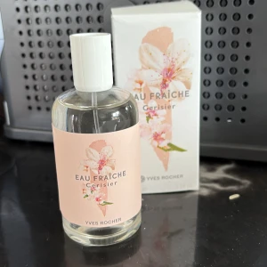 Eau Fraîche Cerisier parfym Yves Rocher - Fräsch parfym från Yves Rocher, Eau Fraîche Cerisier. Flaskan är genomskinlig med vit kork och har en ljusrosa etikett med körsbärsblommor. Kommer i matchande ask med blommigt motiv. Doften är inspirerad av körsbärsblom.
