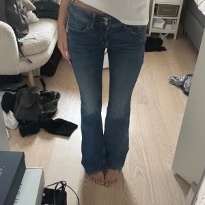 Blå lågmidjade bootcut jeans - Säljer lågmidjade bootcut ANGELIC jeans från H&M Divided i storlek 36. De har två stycken knäppta fickor på baksidan som går att öppna!💗