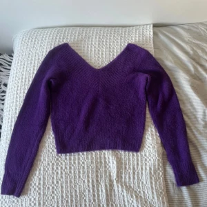Lila v-ringad stickad tröja  - Supermjuk lila stickad tröja i storlek XS, men passar även S. Tröjan har en v-ringning och en vanlig passform. Använd nästintill aldrig så den är i nyskick! 
