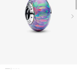 Pandora glittrig lila berlock - Superfin Pandora-berlock i lila med glittriga inslag av grönt, rosa och blått. Rund form med silverdetaljer och ett färgstarkt, shelf oanvänd och nytt skick, nypris 549💗🥰