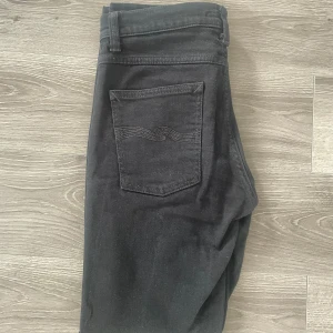 Nudie Jeans Lean Dean 32/32 - Säljer nu ett par svarta Nudie Jeans i modellen Lean Dean 32/32. De är i väldigt fint skick och har inga defekter. Säljer då de var lite för små på mig. Det är bara att höra av sig vid minsta fundering🤩