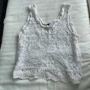 Spetsminne med broderi - Ett vitt spetslinne med broderi! Passar perfekt till alla kläder! Har aldrig använt den eftersom den är för liten på mig.