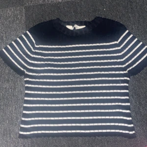 Randig svartvit stickad tröja H&M - Säljer en svart och vit randig stickad tröja från H&M. Tröjan har korta ärmar, rund halsringning och ribbad struktur. Perfekt för dig som gillar en klassisk men chill stil. Passar till både jeans och kjol.