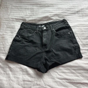 Svarta jeansshorts - Snygga svarta jeansshorts från H&M i klassisk modell. Perfekta till sommaren och lätta att matcha med allt. Stängs med knapp och dragkedja framtill.