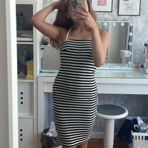 Randig tubklänning från Gina Tricot XS - Säljer en svartvit, ribbad tubklänning från Gina Tricot i storlek XS. Klänningen är kort, figurnära och har horisontella ränder. Perfekt för dig som gillar en enkel men snygg look. Materialet är stretchigt och bekvämt.