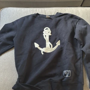 Marinblå sweatshirt Zara med ankare - Snygg marinblå sweatshirt från Zara med stort broderat ankare framtill och patch med texten 'Salty Navy'. Klassisk rund hals och långa ärmar. Perfekt för dig som gillar nautisk stil och vill ha en chill vibe.