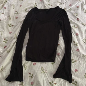 Svart långärmad topp Gina Tricot - Säljer en svart långärmad topp från Gina Tricot i storlek XXS. Toppen har en tight passform, rundad urringning och långa ärmar med lätt utsvängda avslut. Perfekt att styla med jeans eller kjol för en clean look.