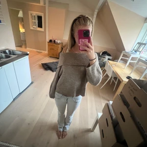 Beige offshoulder stickad tröja H&M - Supermysig beige stickad tröja från H&M i offshoulder-modell. Tröjan har bred krage, långa ärmar och en loose fit som ger en chill vibe. Perfekt att matcha med jeans eller kjol för en avslappnad look. Så fin som är perfekt till hösten!
