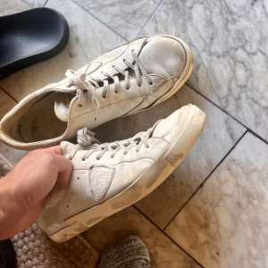 Vita Philippe Model sneakers - Snygga vita sneakers från Philippe Model med klassisk låg profil och rund tå. Skorna har snörning och en diskret logga på sidan. Modell: PM178EDT, finns ej att köpa längre. Säljes i befintligt skick, därav billigt pris! Box medföljer!